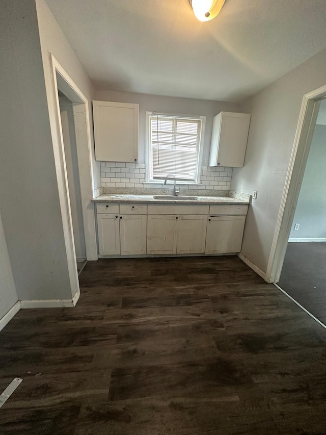 kitchen featuring tasteful backsplash, white cabinetry, dark hardwood / wood-style floors, and sink