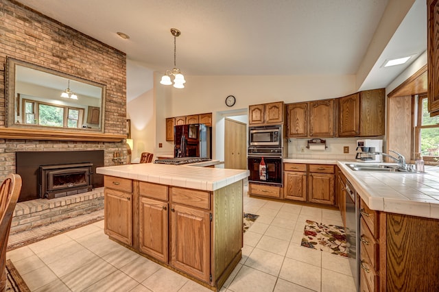 kitchen with a chandelier, tile countertops, lofted ceiling, and black appliances