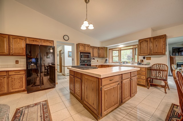 kitchen with black appliances, pendant lighting, light tile patterned floors, a kitchen island, and lofted ceiling