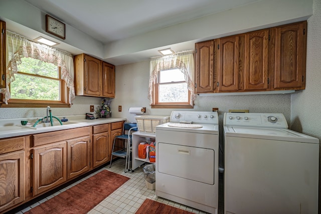 laundry room featuring a wealth of natural light, sink, cabinets, and independent washer and dryer