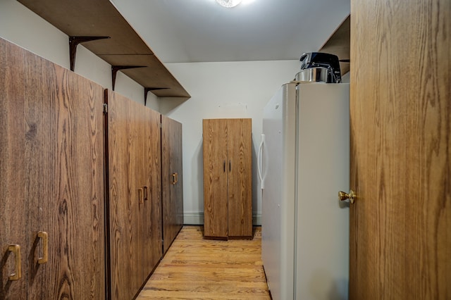 corridor featuring a baseboard heating unit and light hardwood / wood-style flooring