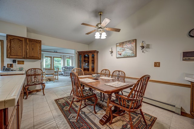 tiled dining area featuring a textured ceiling, vaulted ceiling, and ceiling fan