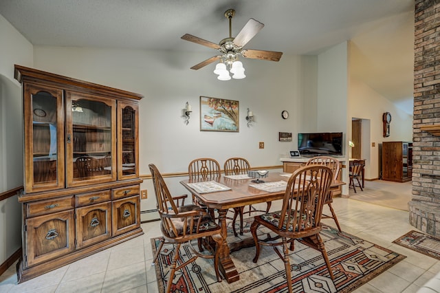 dining space featuring ceiling fan, light tile patterned floors, and vaulted ceiling