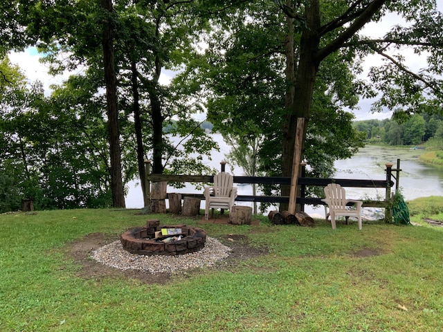 view of yard featuring a water view and an outdoor fire pit