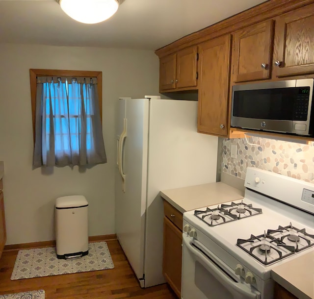 kitchen featuring decorative backsplash, white gas stove, and dark wood-type flooring