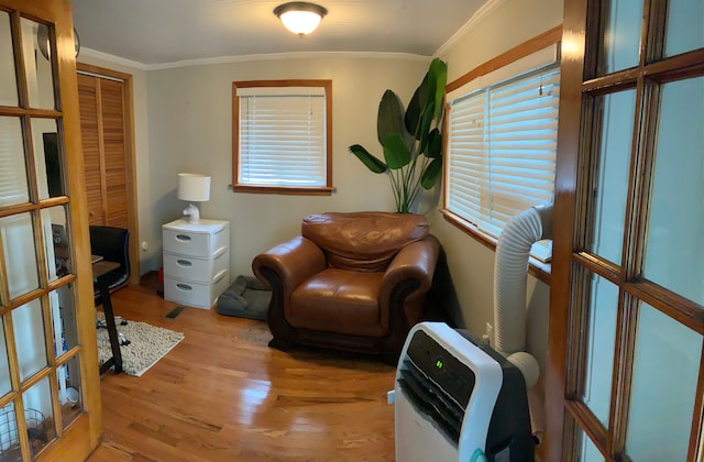 living area with light hardwood / wood-style flooring and crown molding