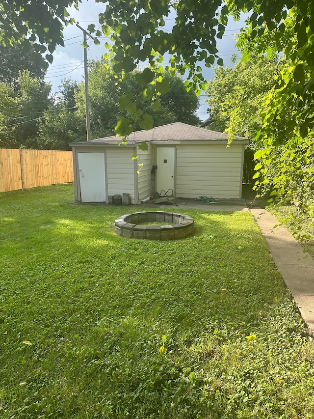 view of yard featuring a storage shed and an outdoor fire pit