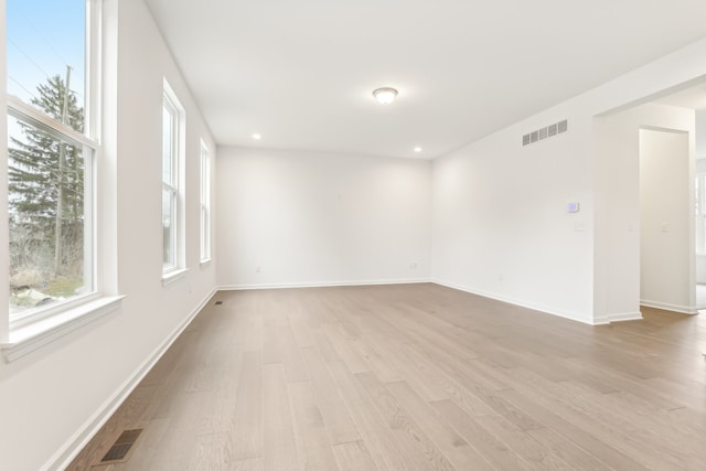 spare room featuring light hardwood / wood-style flooring and plenty of natural light