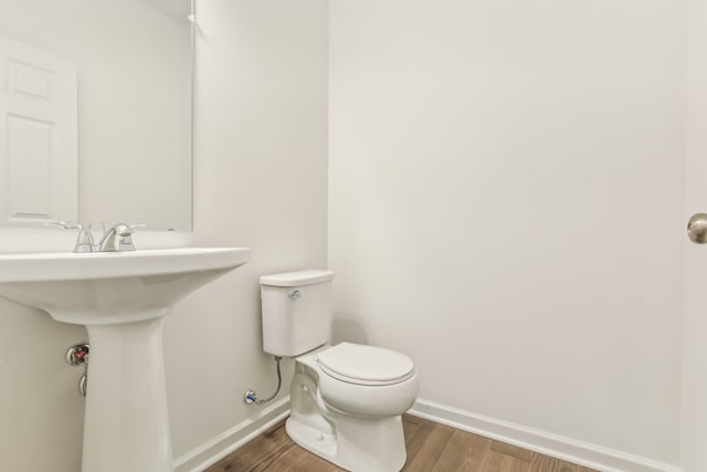 bathroom with toilet and wood-type flooring