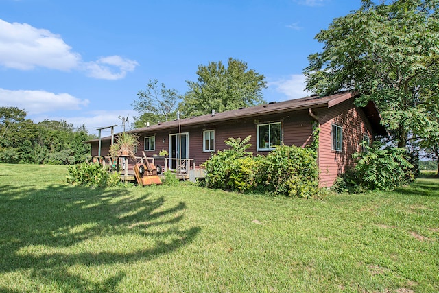 back of property featuring a deck and a yard