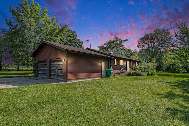 property exterior at dusk with a garage and a lawn