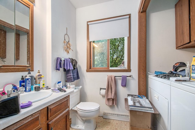 bathroom with toilet, vanity, a baseboard heating unit, and independent washer and dryer