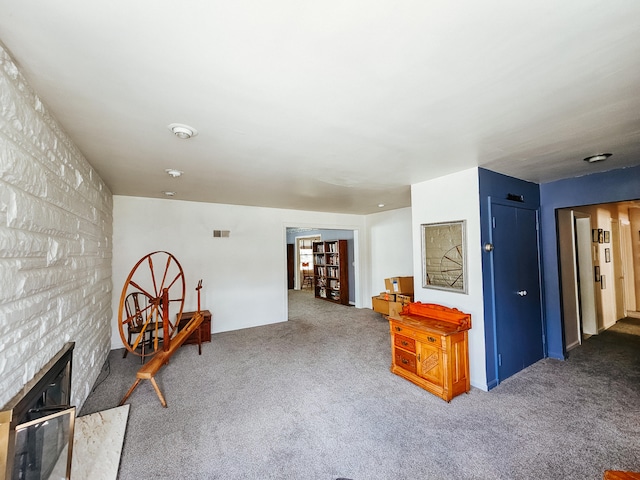 sitting room with a large fireplace and carpet floors