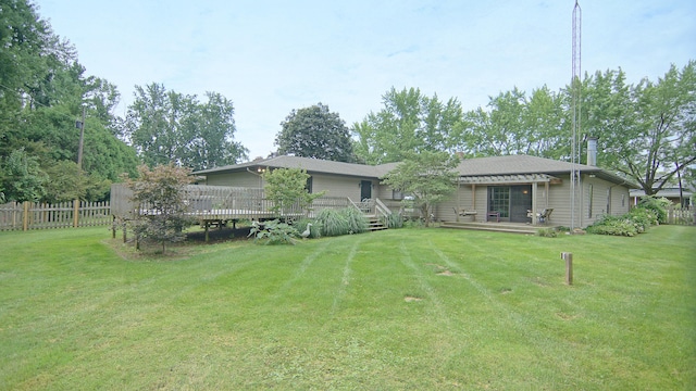 back of property with a yard and a deck