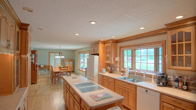 kitchen with a center island, white appliances, sink, hanging light fixtures, and a textured ceiling