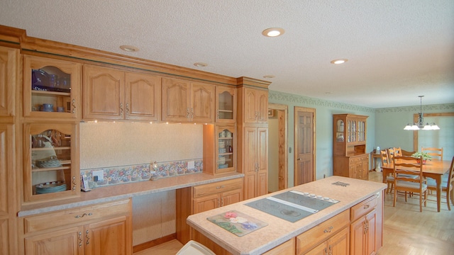 kitchen with light hardwood / wood-style flooring, a notable chandelier, a textured ceiling, decorative light fixtures, and electric cooktop