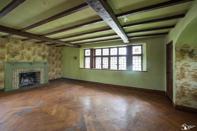 unfurnished living room featuring dark parquet flooring and a fireplace