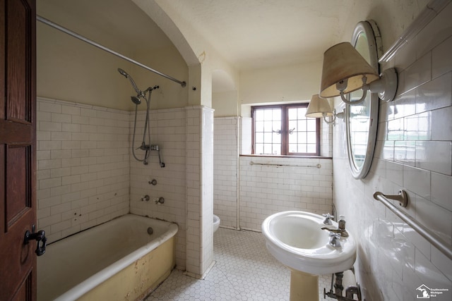 full bathroom with sink, tile patterned flooring, toilet, tile walls, and tiled shower / bath