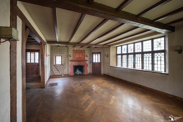 unfurnished living room with beamed ceiling and dark parquet floors