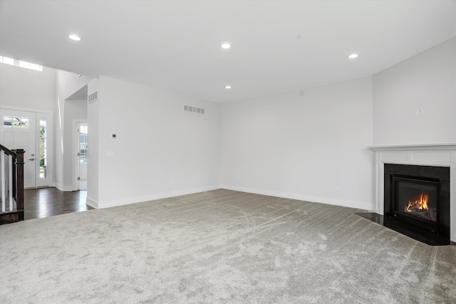 unfurnished living room with dark colored carpet