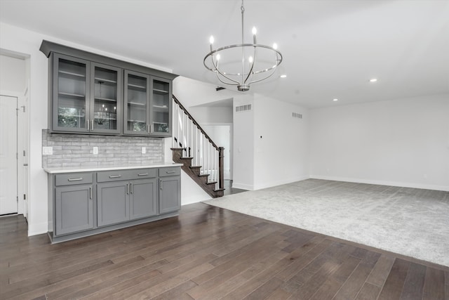 667 Allegheny Dr, South Lyon, MI 48178 - bar area with a chandelier, dark wood-type flooring, stairway, recessed lighting, and backsplash