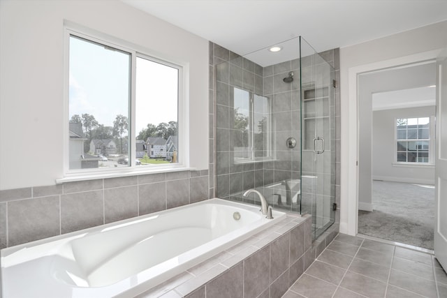 bathroom with tile patterned flooring and shower with separate bathtub