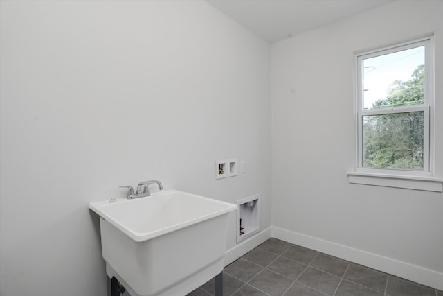 laundry area featuring dark tile patterned flooring, sink, and hookup for a washing machine