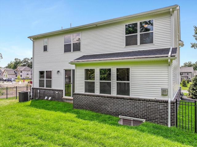 rear view of property featuring a lawn and central AC