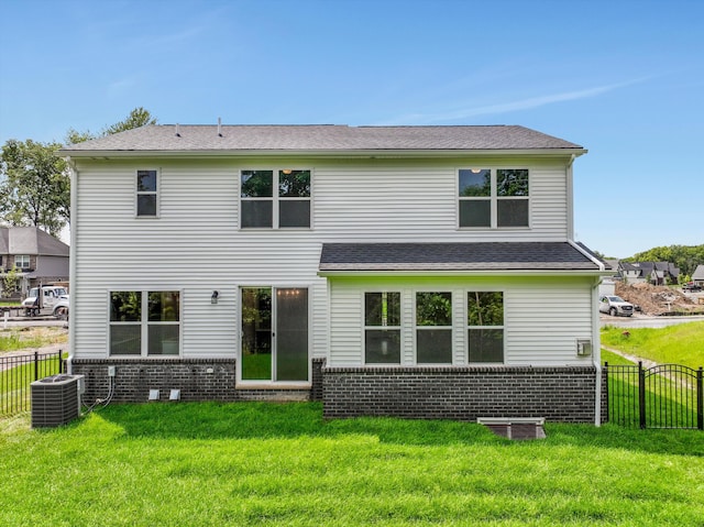 rear view of property with a lawn and central air condition unit