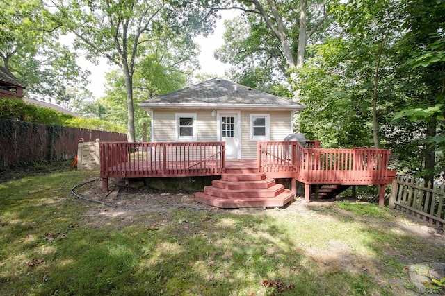 back of house featuring a lawn and a wooden deck