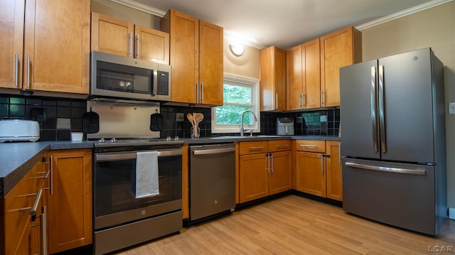 kitchen featuring backsplash, light hardwood / wood-style floors, crown molding, and appliances with stainless steel finishes