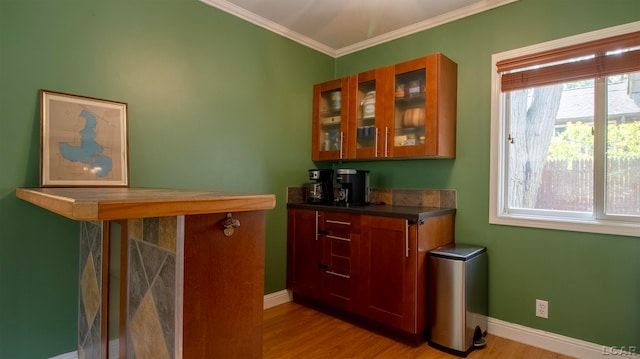 bar featuring light wood-type flooring and crown molding