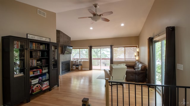 4241 Echo Cv, Manitou Beach, MI 49253 - living area with vaulted ceiling, ceiling fan, a tile fireplace, plenty of natural light, and light wood-style floors
