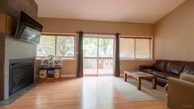 living room featuring a tile fireplace and hardwood / wood-style floors