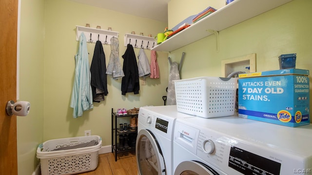 laundry room with independent washer and dryer and light hardwood / wood-style flooring