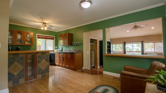 kitchen with crown molding, sink, and light hardwood / wood-style floors