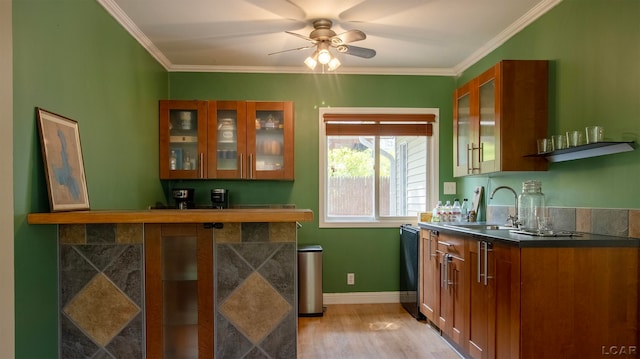 kitchen featuring ceiling fan, crown molding, sink, light hardwood / wood-style flooring, and black dishwasher