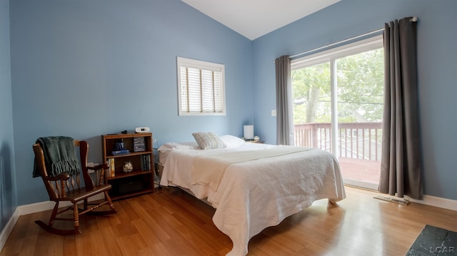 4241 Echo Cv, Manitou Beach, MI 49253 - bedroom featuring vaulted ceiling, access to outside, multiple windows, and wood finished floors