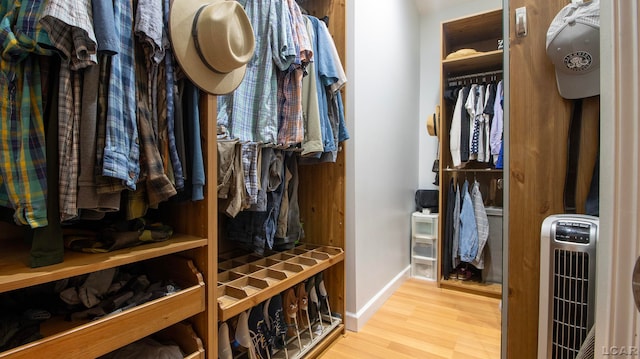 spacious closet with light hardwood / wood-style floors and heating unit