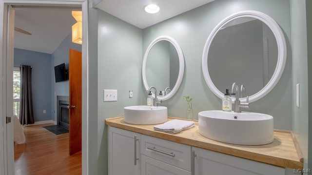 4241 Echo Cv, Manitou Beach, MI 49253 - full bathroom featuring double vanity, wood finished floors, baseboards, and vaulted ceiling