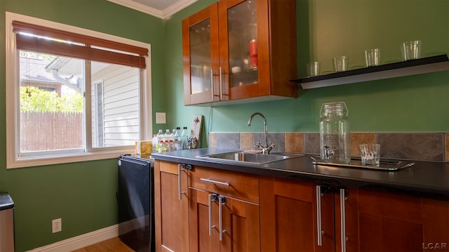 bar with wood-type flooring, black fridge, crown molding, and sink