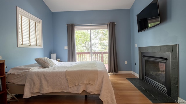 4241 Echo Cv, Manitou Beach, MI 49253 - bedroom featuring access to exterior, wood finished floors, a tile fireplace, and baseboards