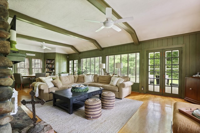 sunroom with lofted ceiling with beams, ceiling fan, and french doors