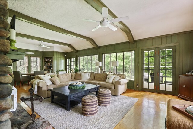 9300 Ormes Rd, Vassar, MI 49768 - living room featuring a ceiling fan, hardwood / wood-style floors, wooden walls, and french doors
