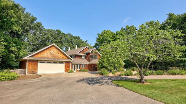 craftsman house featuring a garage and a front lawn