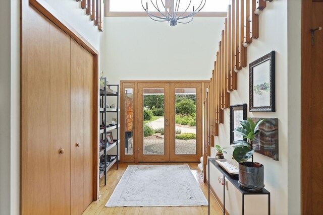9300 Ormes Rd, Vassar, MI 49768 - entrance foyer featuring a high ceiling, light wood-style flooring, french doors, and a chandelier