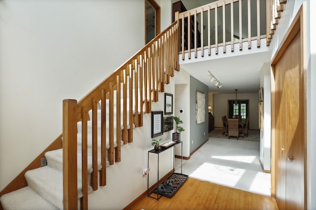 staircase featuring hardwood / wood-style floors and rail lighting