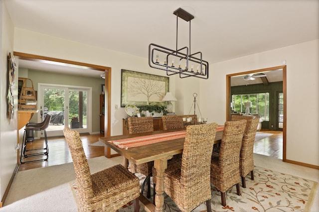 dining space with light wood-type flooring and an inviting chandelier