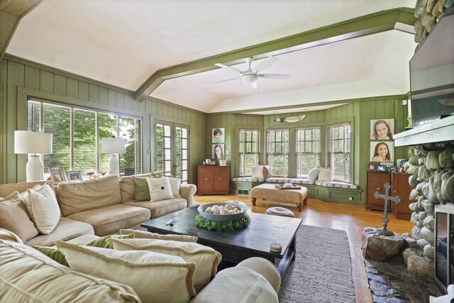 9300 Ormes Rd, Vassar, MI 49768 - living area featuring a fireplace, wood finished floors, vaulted ceiling, a ceiling fan, and wood walls