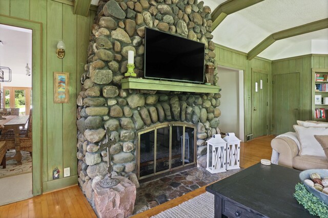 9300 Ormes Rd, Vassar, MI 49768 - living room with wood walls, wood finished floors, and a stone fireplace